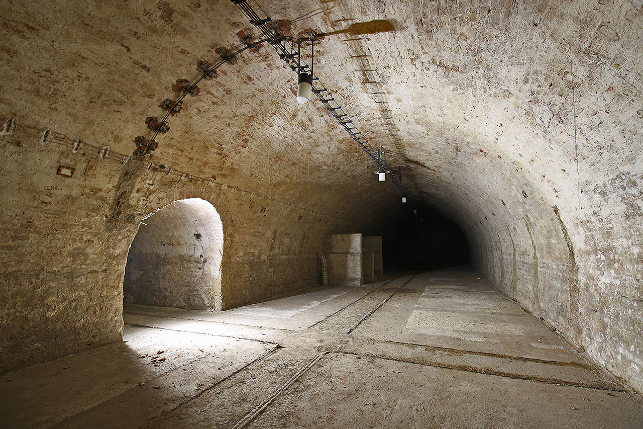 Světlo se line z dodatečně vybudované 10 m dlouhé spojovací chodby, která propojila železniční tratě ve sklepech za domy č. 98 a 100.