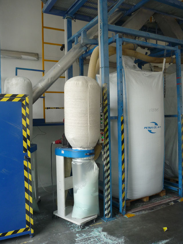 A to už je zásobník namletého polyetylentereftalátu, jak se PET celým jménem jmenuje. Jemný prach se musí v pytlech řádně udusat. Ty pak putují do Česka i do zahraničí, kde z nich vyrobí oblečení, stahovací pásky, technické textilie nebo, v případě zvlášť kvalitního materiálu, nové lahve.