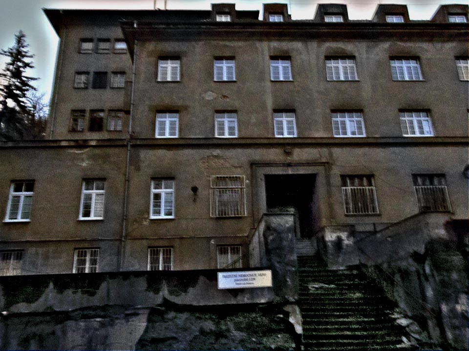 Zvenčí vypadá omšelá budova hrůzostrašně. V oknech je věčně tma.