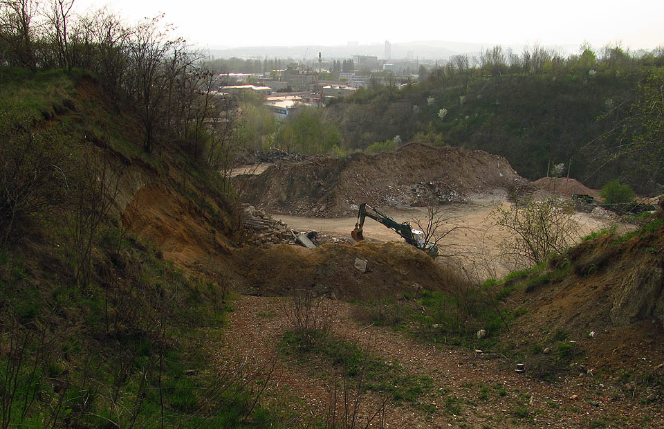 Z bránou míří cesta do podivného území. Terén tu má nějaký divný, nepřírodní tvar.