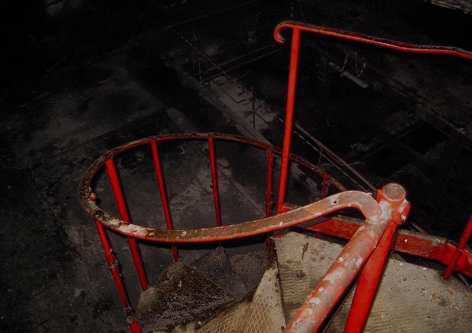 Vratké točité schody klesající hlouběji a hlouběji napříč patry.