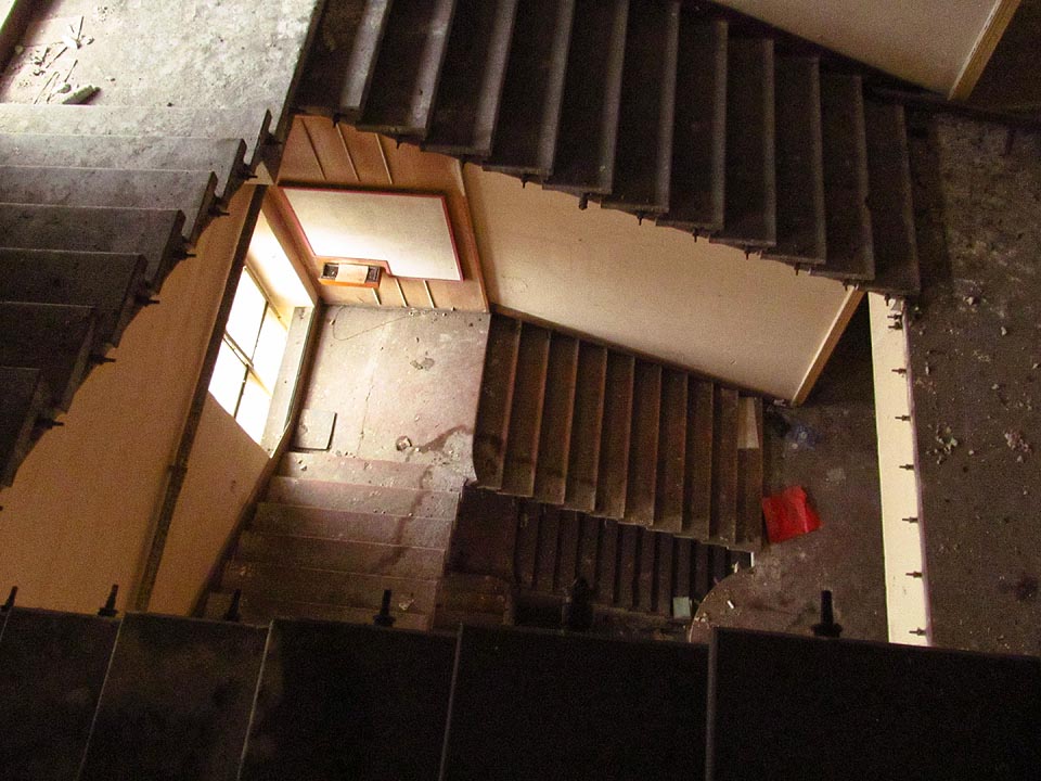 Do hlavní budovy lze sestoupit po schodišti z půdy. Zábradlí se však již někomu hodilo jinde a tak nezbývá než se opatrně držet při stěně auly.