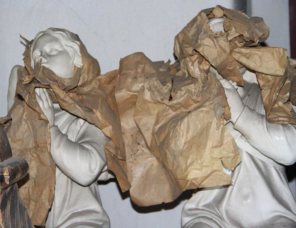 Odsvěcený kostel je plný lehce strašidelných záhadných předmětů. Sošky světců snad kdysi někdo zavinul do balícího papíru, aby se modlily v přítmí kostelní věže na věky.