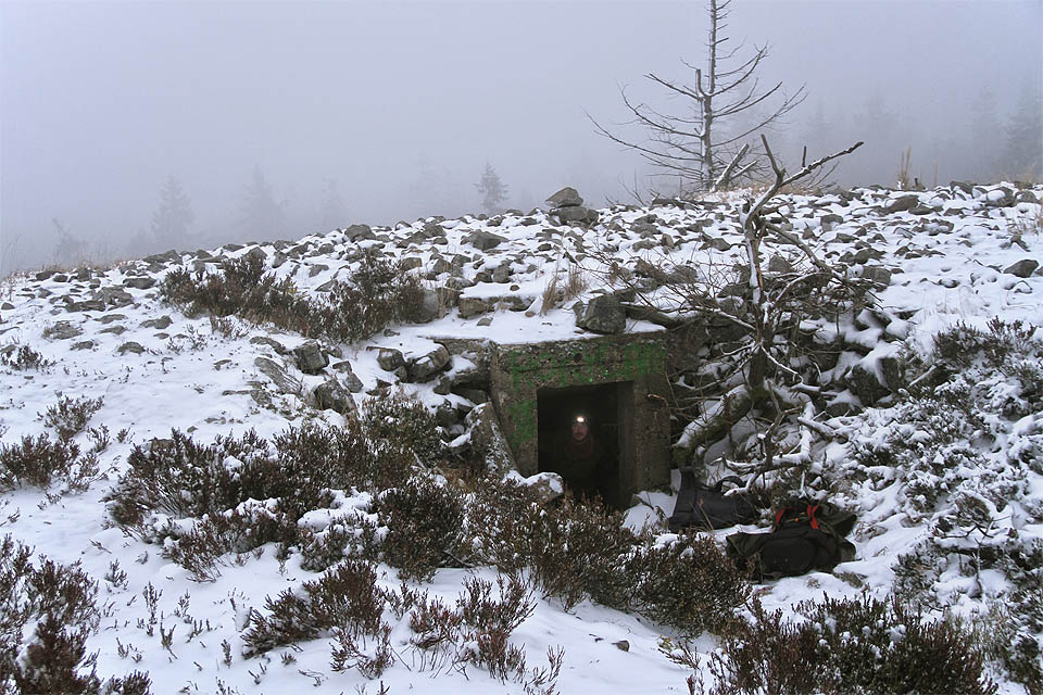 Tady to je. V kamenité pláni a sněhové smršti nacházíme podle GPS souřadnic nenápadný otvor do dělostřelecké pozorovatelny. Tady si můžeme stáhnout kapuce a podívat se na mapu.