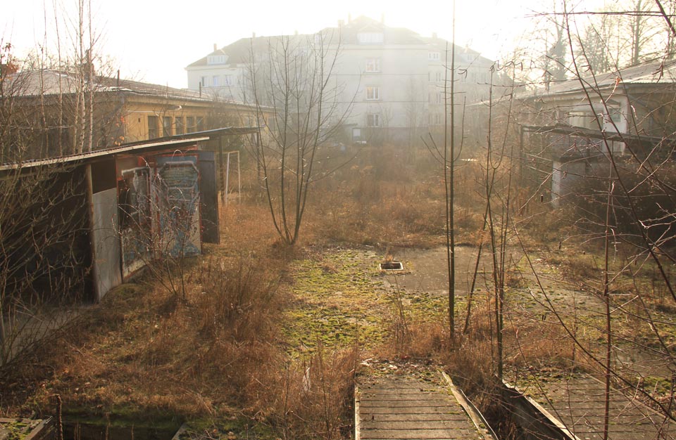 Ranní slunko rozhání mlhu nad areálem opuštěných kasáren na Kraví hoře.