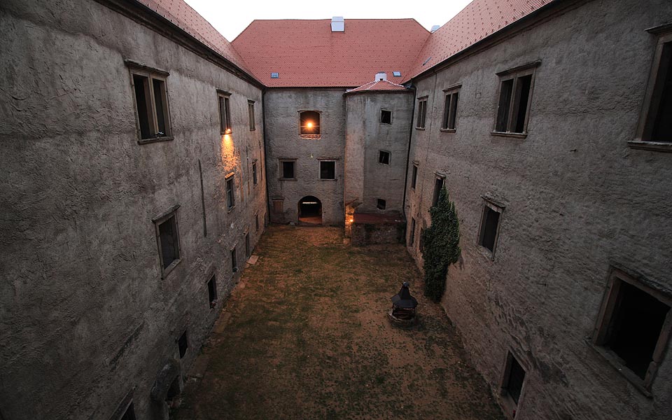 Díky betonem sanované fasádě vypadá nádvoří bez výzdoby trošku jako ponurý vězeňský dvůr. Má to svůj půvab. Prohlídce hradu se věnujeme až do setmění.