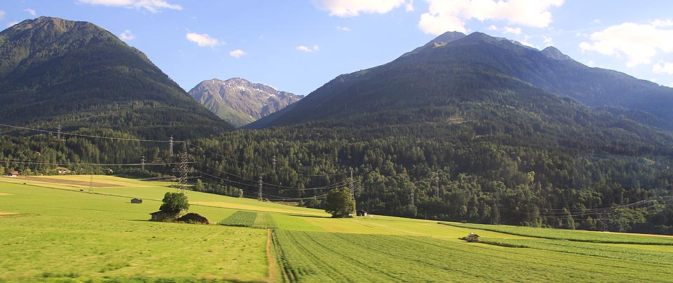 Před Telfsem vjíždíme do pořádných hor. I přes špinavé sklo v okně je vidět, že na začátku července zde na hřebenech ještě leží sníh. Hranice se Švýcarskem se blíží.
