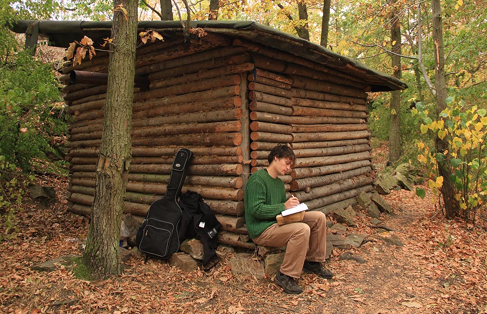 Stopař píše zápis do srubovní knihy.