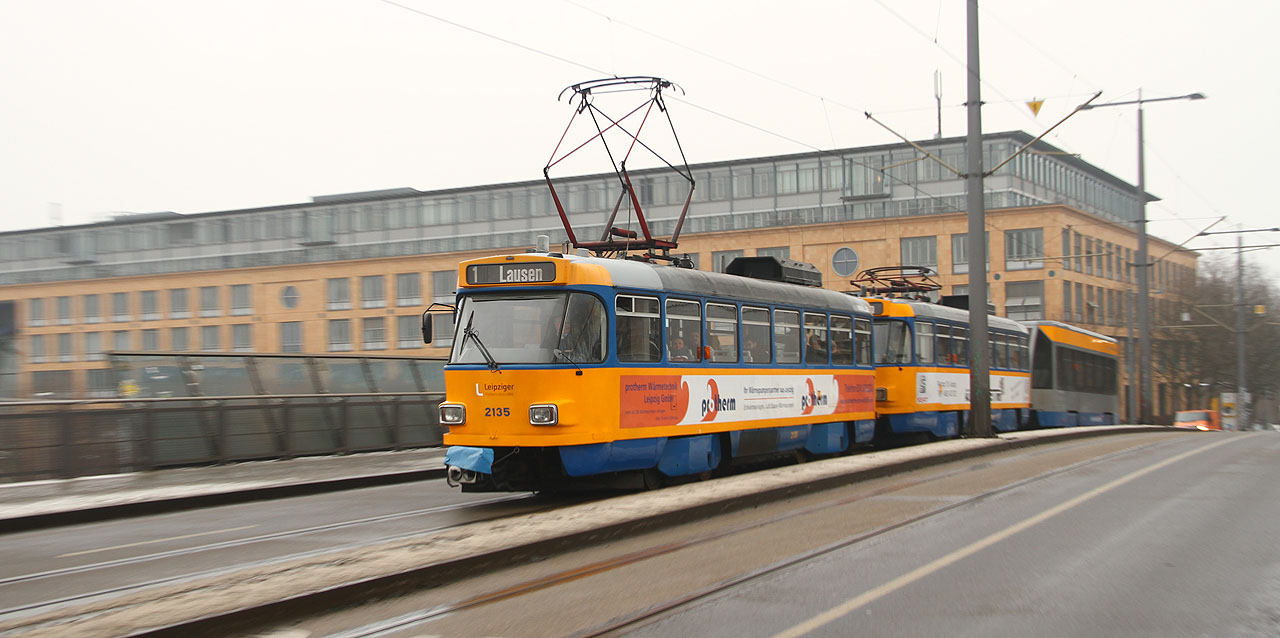 Trojvozový vlak linky č. 1 míří po mostě přes kolejiště hlavního nádraží do Lausenu.