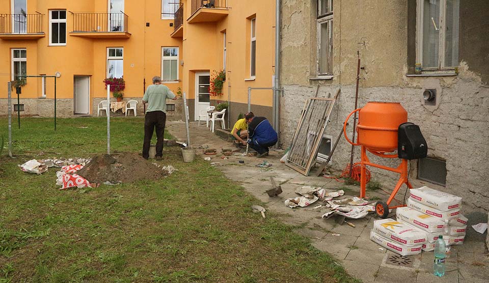 Práci s betonováním základů pro sloupky a opěry plotu nám výrazně zjednodušila míchačka výhodně zapůjčená v nedalekém železářství. Se sousedem jsme ji dotáhli domů na kolečkách po silnici ručně.
