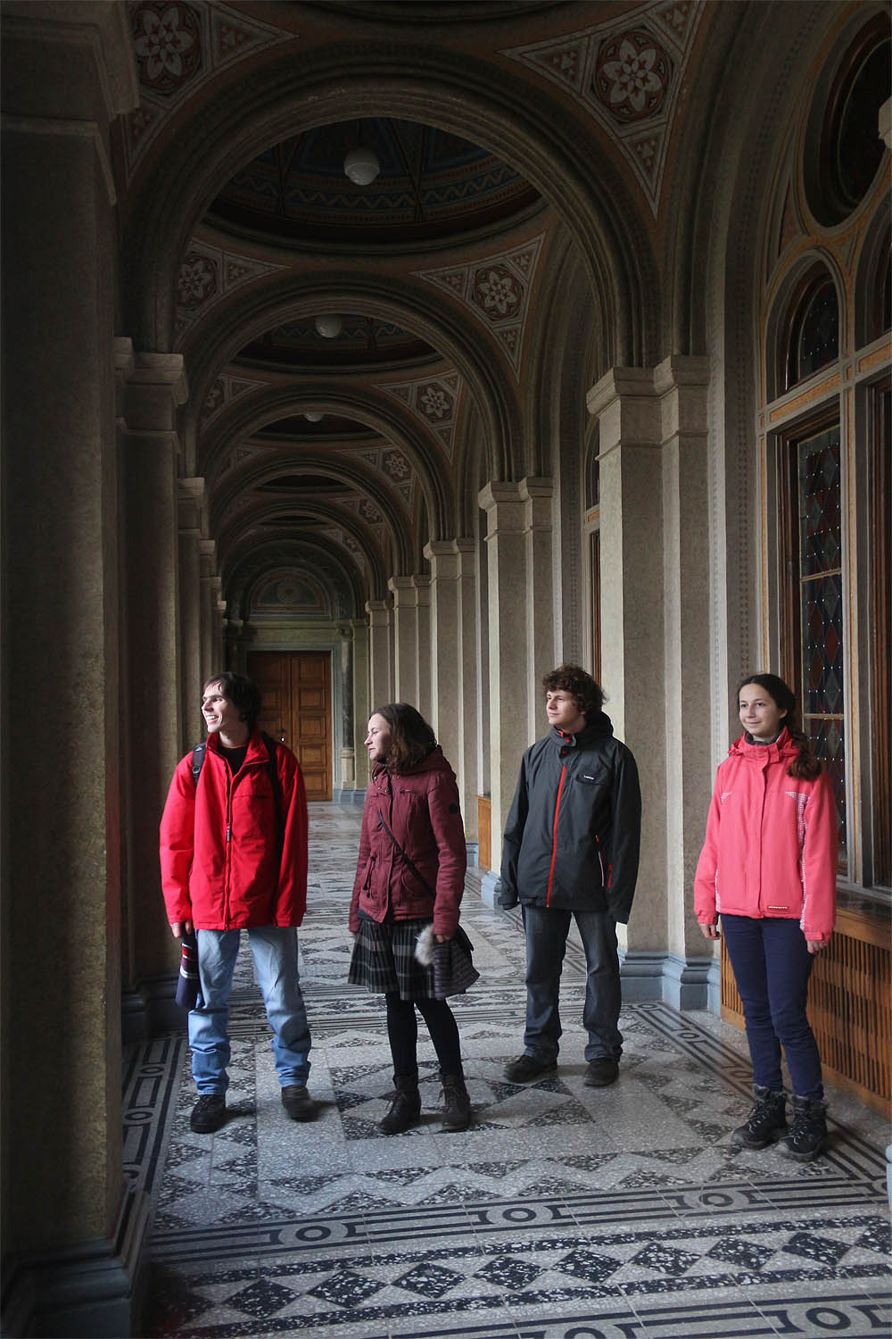 Společná fotka na chodbě univerzity s pohledem upřeným k botanické zahradě.