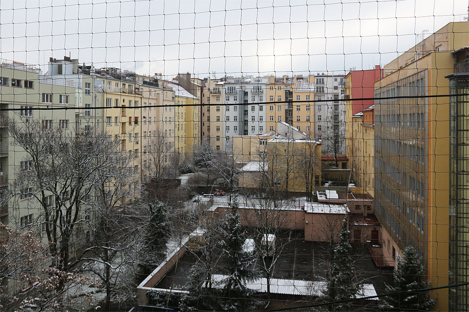 Výhled z okna byl v 80. letech, kdy se sem Jestřáb nastěhoval, o poznání méně barevný. Za to mohl okouzlit romantickou oprýskaností omítek. Tak nějak musel vypadat dvůr, přes který zachytil Vláďa tajemné signály baterkou, jež ho dovedly až do Země nikoho.
