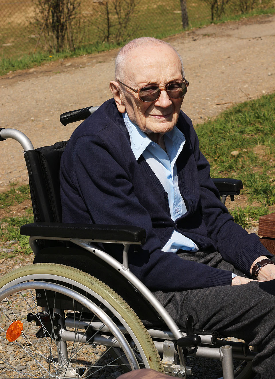 Oslavenec se nepouštěl do boje s berlemi a nechal se raději vézt ve skládacím vozíku. S novým sestřihem vypadal trochu jako plešoun.