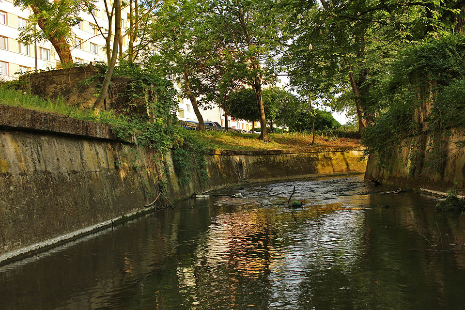 Úsek podél ulice Za Mostem je silně zregulován a náhon zde teče mezi dvěma betonovými stěnami. Původní terén byl o něco níž a náhon se tu větvil, vytvářeje ostrov, na kterém stál kostel sv. Jiljí.