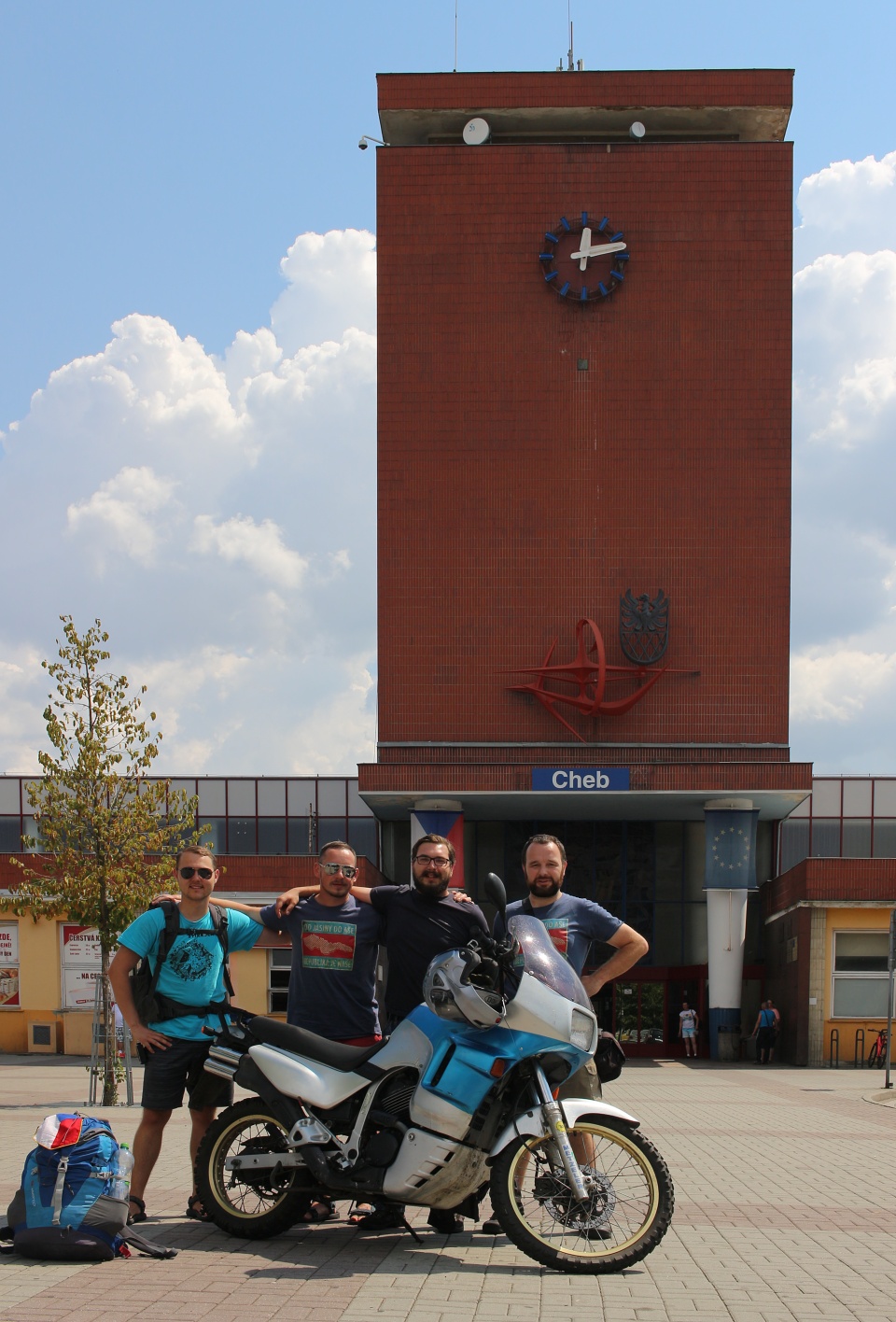 Zpátky v Chebu. Před netypickou nádražní budovou z období Československa se setkáváme po neuvěřitelných 14 letech s kamarádem Datlem z Karlových Varů. Přijíždí na motorce, které je ovšem (bohužel) japonské výroby. Počítáme ji po vlaku, kterým jsme přijeli, autobuse, který jej částečně nahradil, autě, kterým nás svezli novináři a vlastních nohách za pátý druh dopravního prostředku na naší cestě.