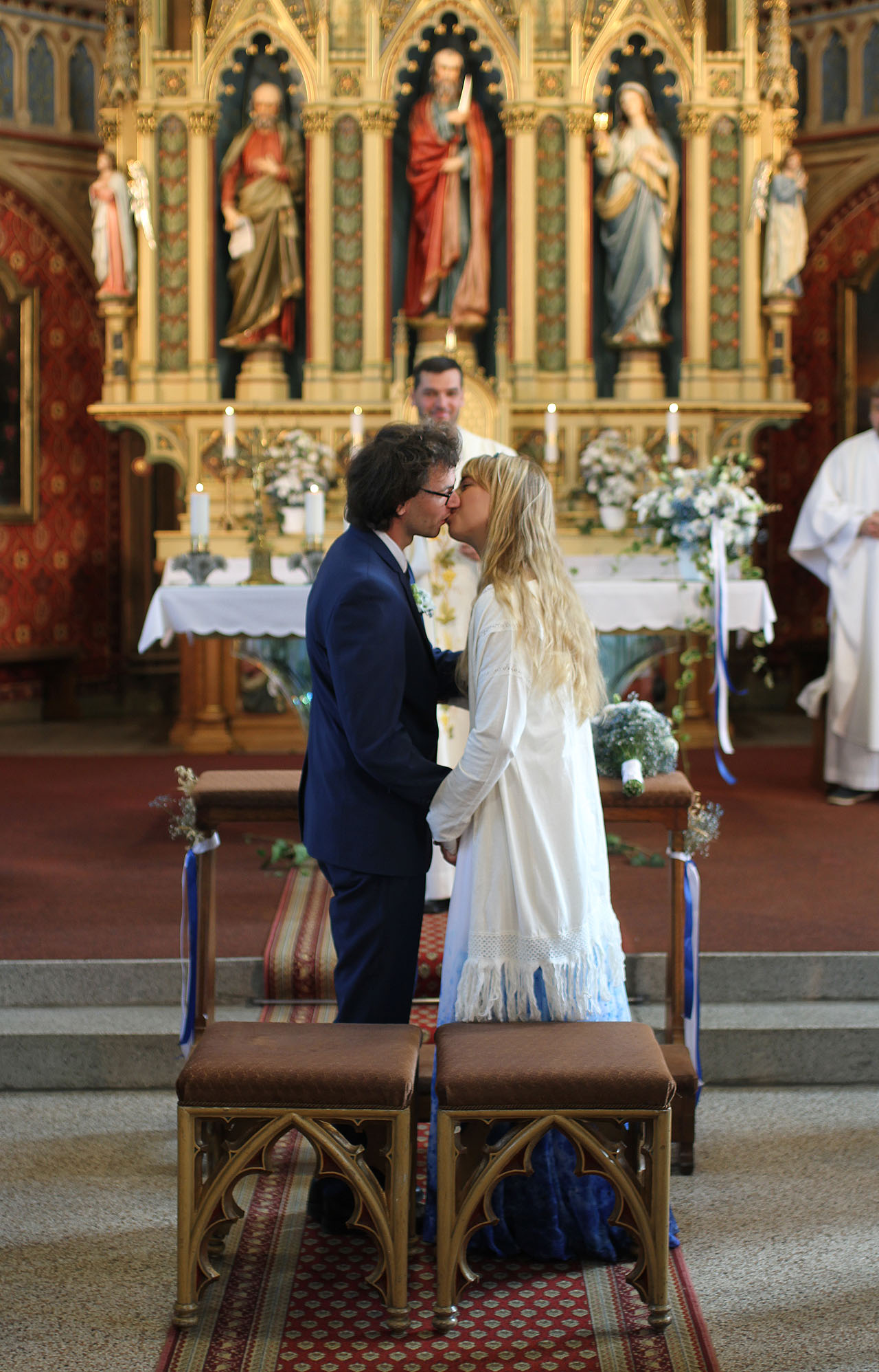 A je to! Novomanželský polibek pod laskavým dohledem kněze, světců a světic a Anežka s Vaškem jsou navždy svoji.