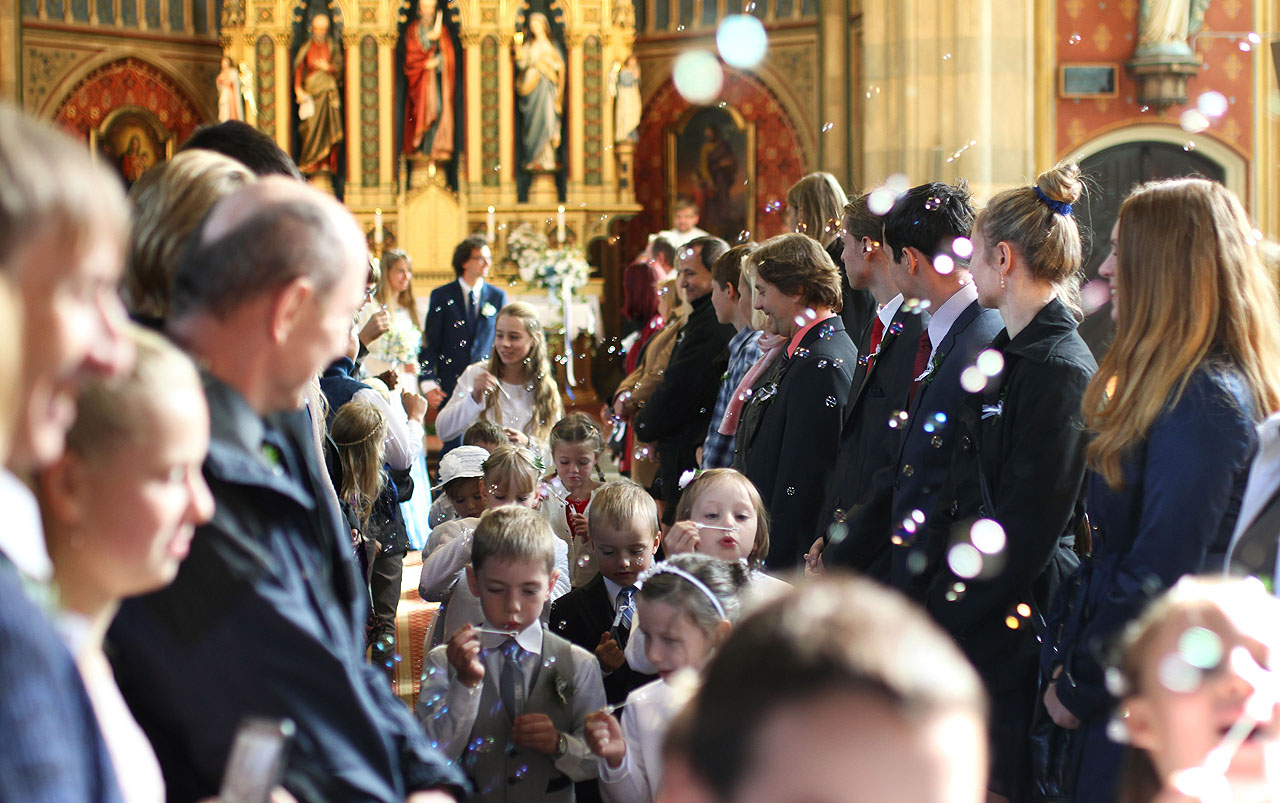 Liška jako pastýřka stáda družiček s bublifuky umetá cestu novomanželům před chrám a do kočáru.