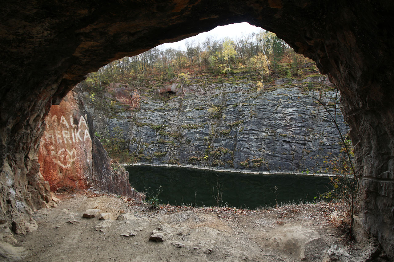 Nápis na skále je jednou z mnoha stop, které v lomech zanechali trampové. Koncem 20. století tady takřka neomezeně vládli. Zpřísňování předpisů a plíživé mizení svobody v podobě ochránců přírody i majitele důlních děl trampy postupně téměř vytlačilo.
