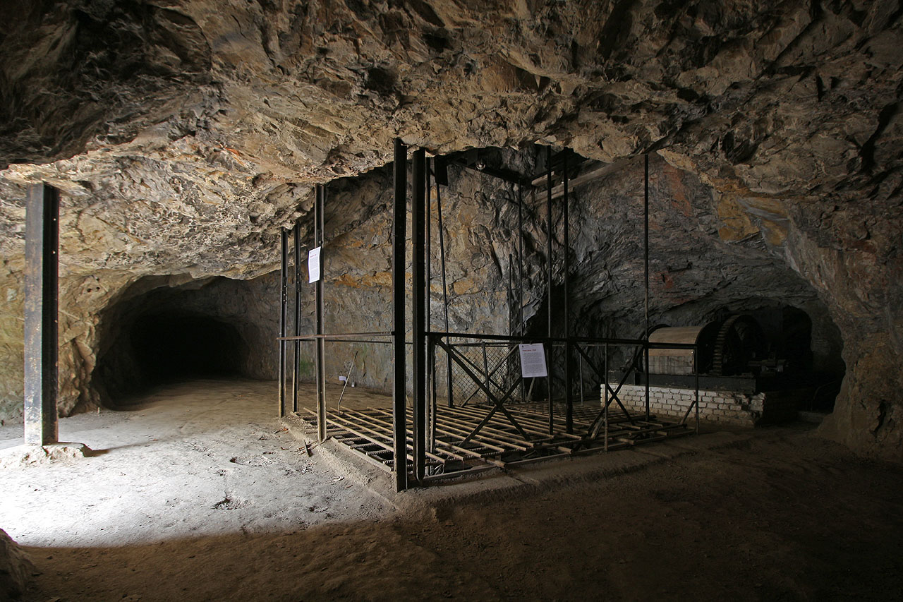 Z dnešního poloostrova v jezeře na úrovni 4. patra se kámen dopravoval vzhůru podzemní zdviží - jakousi slepou jámou. O mohutnosti stroje svědčí v pozadí ukrytý buben navijáku.