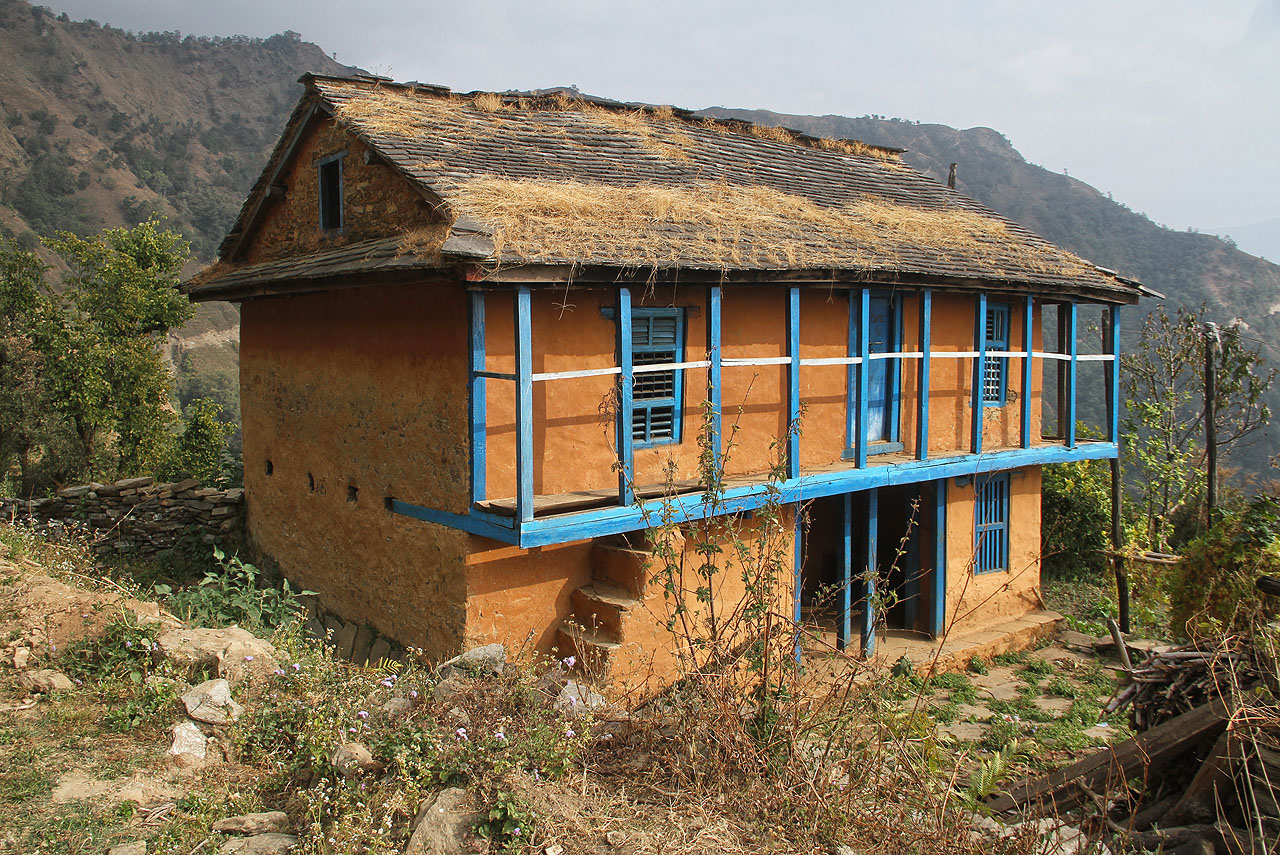 Typický rodinný dům nepálského venkova v mírném pásu - dvě podlaží, stěny z nepálených cihel, malebná veranda, hospodářská půda a sedlová střecha proti letním dešťům. Vaří se na vnější pícce pod schodištěm, topí se dřevem z horského lesa. Uvnitř vytápění neexistuje, nahrazují jej mohutné vrstvy přikrývek. Elektřina, voda, koupelna ani toaleta nejsou k dispozici, dům je ale čistý, úpravný a barevný.