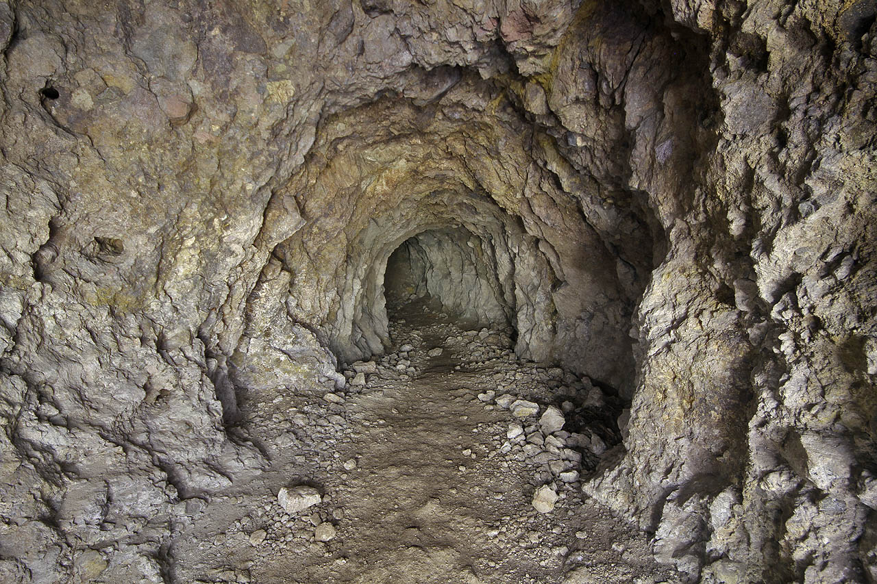 Víceméně přímá chodba nás vede hlouběji do nitra kopce. Teplota stoupá na příjemných 8 °C a tma je tu už stejná jako venku. Do rána se proto raději budeme pohybovat v tunelech nedokončené nacistické továrny.