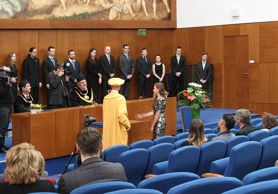 Drobek skládá slib do rukou fakultního pedela, o kterém v posledních pěti letech s oblibou říkávala, že je „žlutý jako kuřátko“.