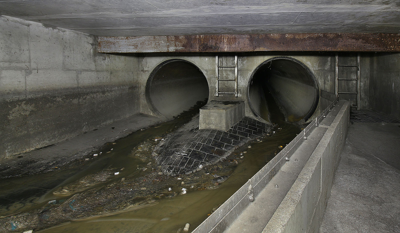 A to už je rozdělovací komora. Sběrač zpod Husitské ulice přivádí splašky až ke zdvojné rouře kmenové stoky vedoucí podél Bratrušovského potoka pod ulicí Jiřího z Poděbrad.