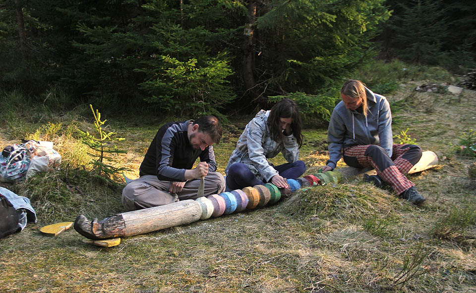 Času není nazbyt. Proto ještě v pátek pokládáme již uhnilý totem a začíná broušení, řezání, pilování a sekání - tak, aby všechno zteřelé dřevo zmizelo a my mohli totem nově namalovat a nalakovat.