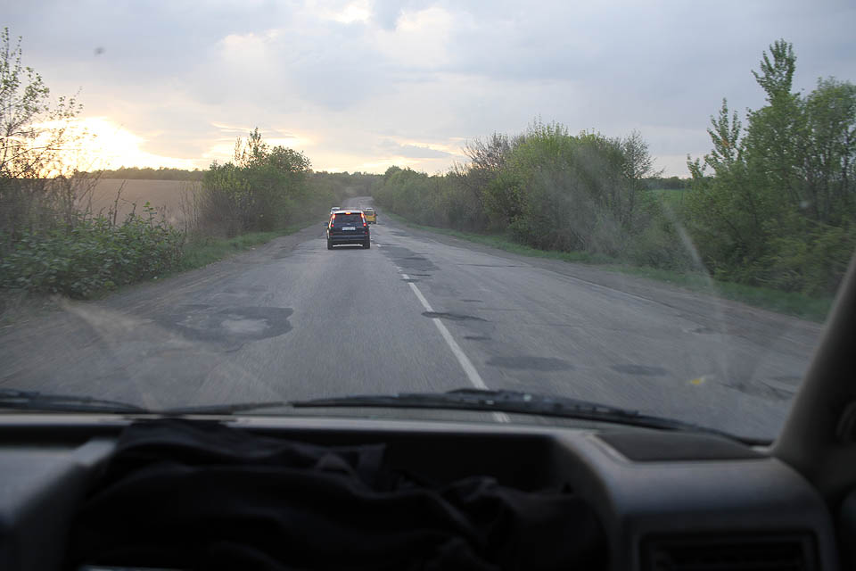 Ukrajinské silnice se obracejí vniveč. Již dříve jsme si na vlastní nápravy ověřili, že cestování po nich je dnymické, nebezpečné a ubíjející. Ulomit si kolo je jednodušší než nespadnout alespoň do jednoho pořádného výtluku.