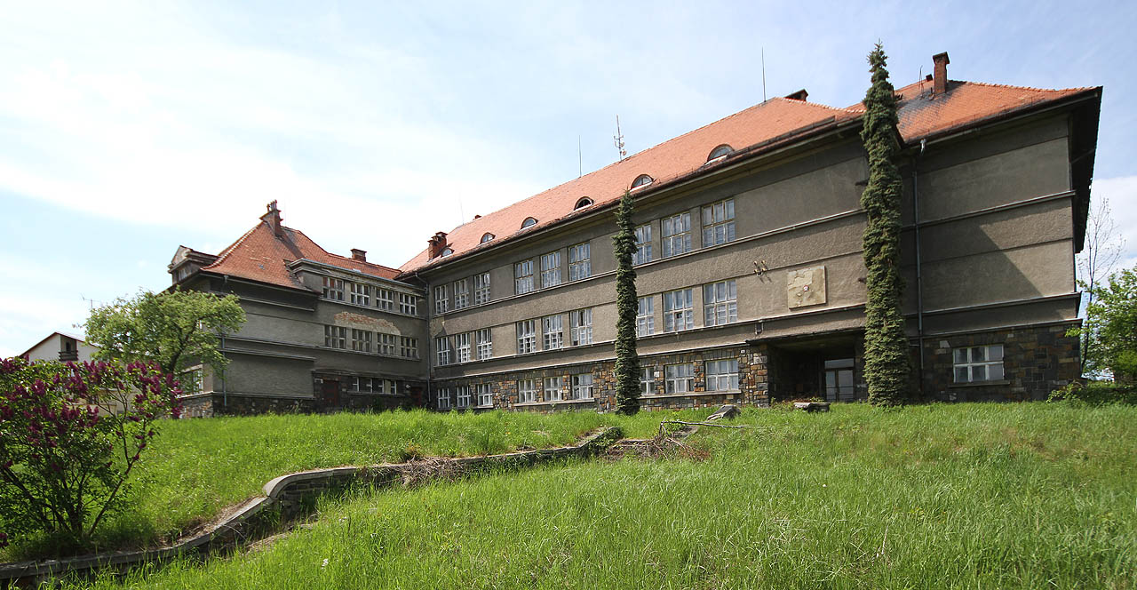 Mohutná prvorepubliková škola byla snad kdysi zemědělským učilištěm. Díky své odlehlé poloze naštěstí nijak nechátrá, i když už je roky opuštěná.