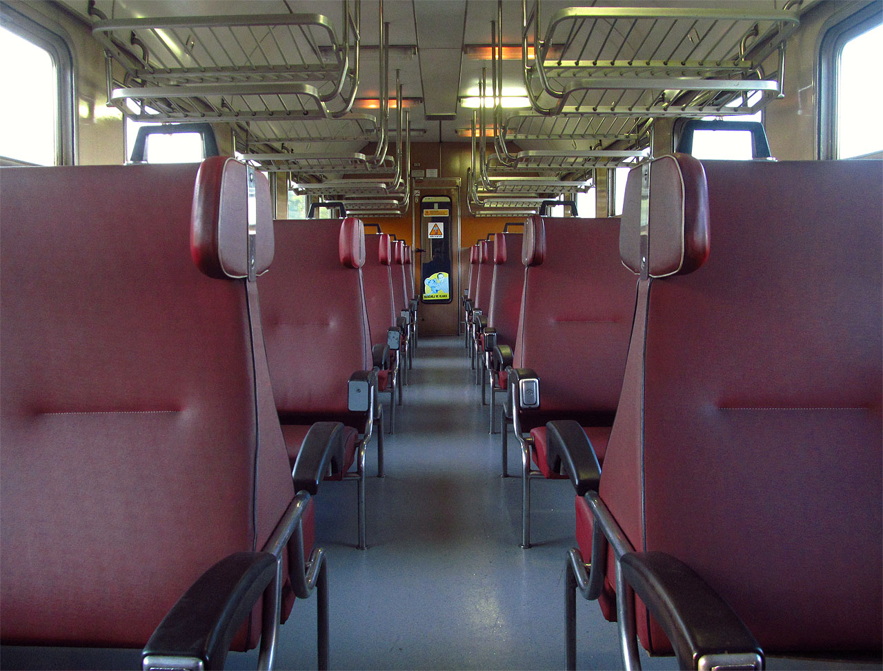 Nebýt přiblblých nálepek se slony, dal by se interiér ranního osobáku označit takřka za originální. Zachovalý dokonce částečně včetně elegantních popelníků v loketních opěrkách sedadel…