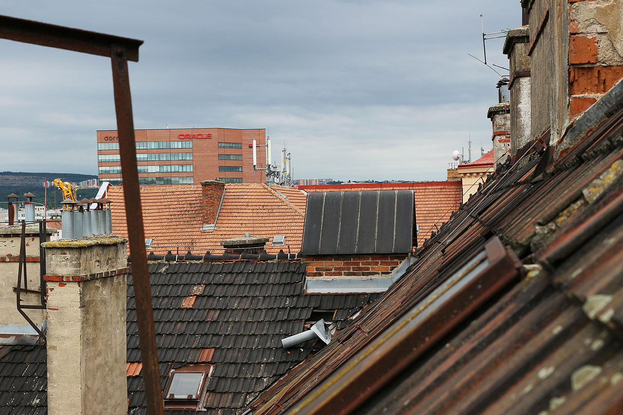 Výhledy na Brno přes střešní tašky zčernalé ještě od kouře z kotlů parních lokomotiv, jež posunovaly na nedalekém <a href="/Tema/Brno hlavní nádraží (žst)">hlavním nádraží</a>.