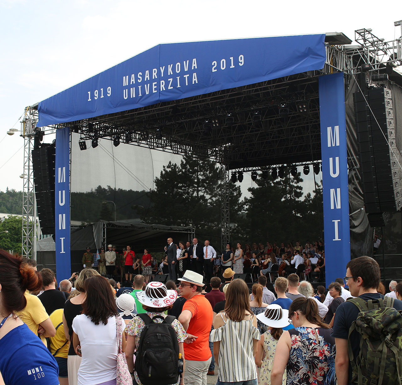 Na pódiu se vystřídali takřka všichni děkani, jakož i své funkční období završující rektor Mikuláš Bek. V extrémním horku léta roku 2019 bylo nutné všechny, kdo přišli oděni v saku, považovat za skutečné hrdiny.