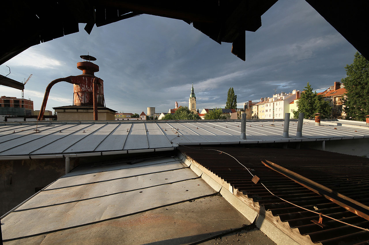 Zpodstřešní výhled na ploché střechy továrních hal.