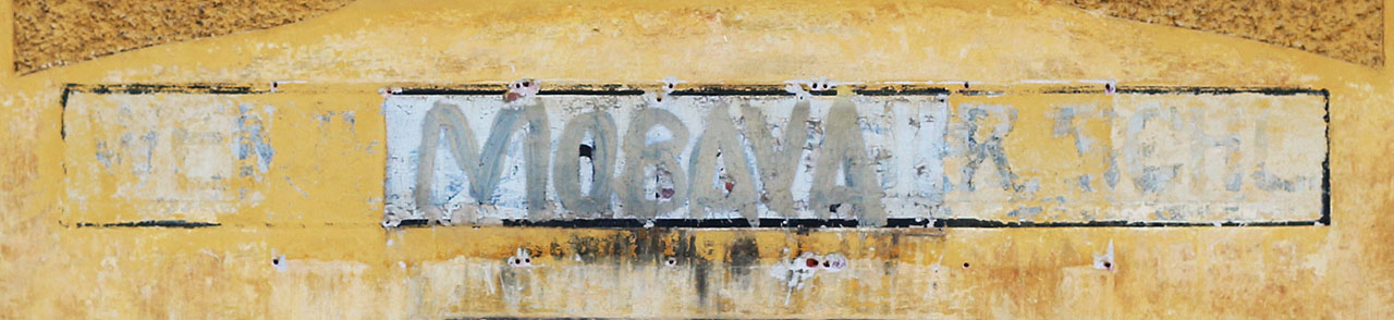 Několik vrstev nápisu na rozlehlé staniční budově ve Vidnavě. Od německého WEIDENAU - HAUGSDORF SCHL. až po vyškrabané MORAVA od místních přihlouplých vandalů.