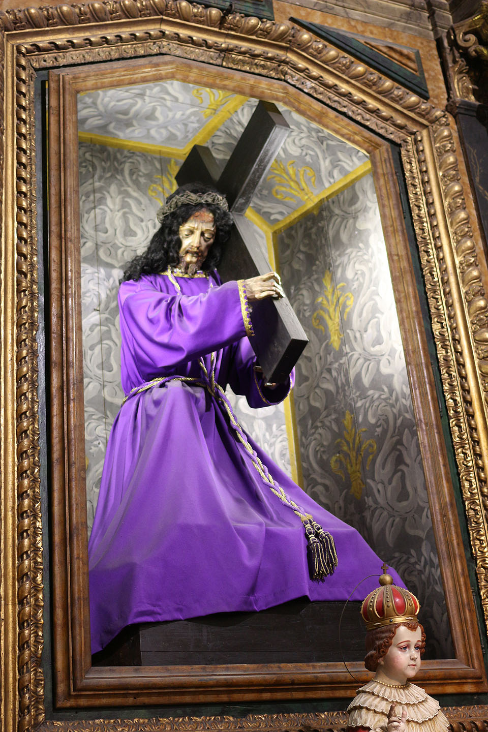 Bizarnost některých sakrálních výjevů je úsměvná - starý Ježíš Kristus se pokouší zabít malého Ježíše Krista křížem.