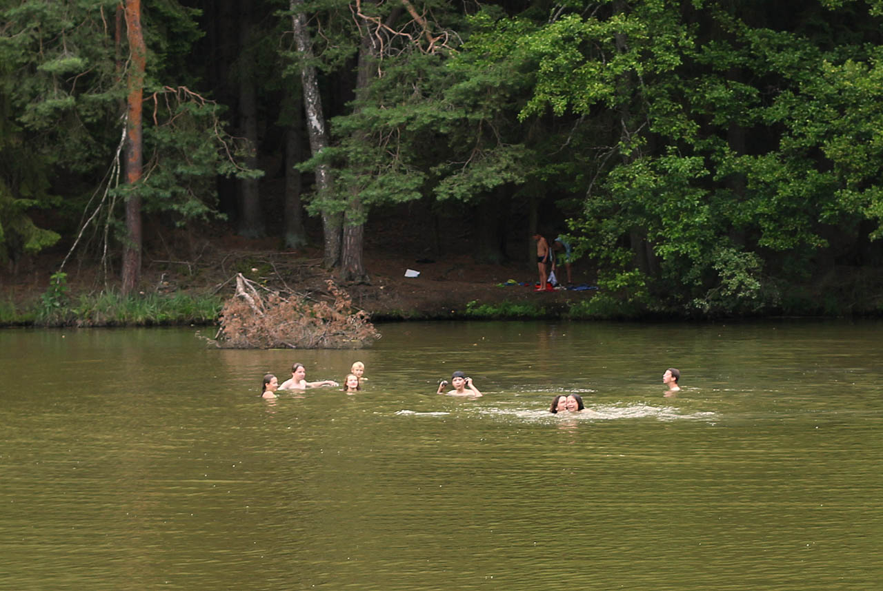 Poslední společné táborové koupání v lesní zelené vodě.
