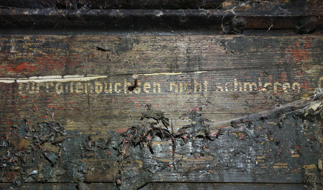 Identifikace vagónu není vzhledem k jeho stáří jednoduchá. Pomoci by snad mohl německý nápis „Türrollenbuchsen nich schmieren“, tedy něco jako „Nemazat kuličková ložiska dveří“.