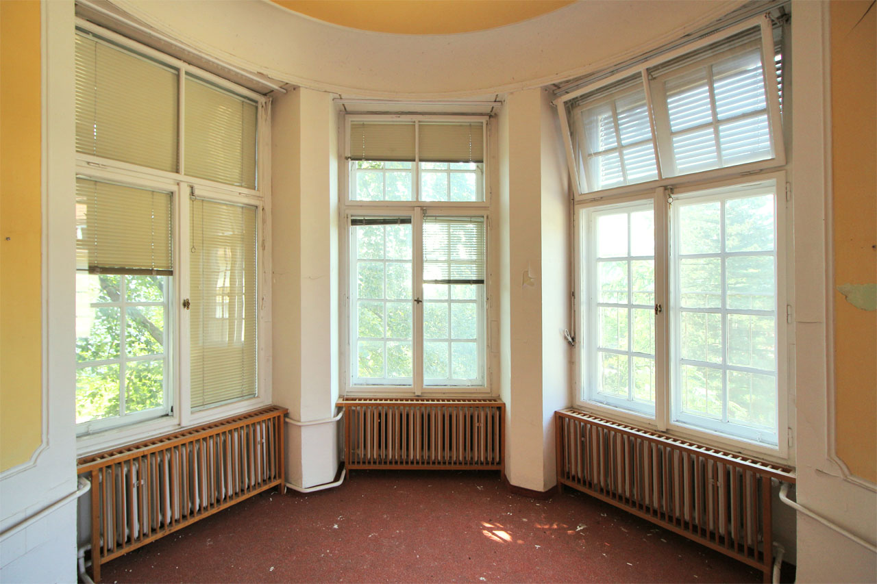 Pohled z arkýře do bujně zarostlé zahrady.