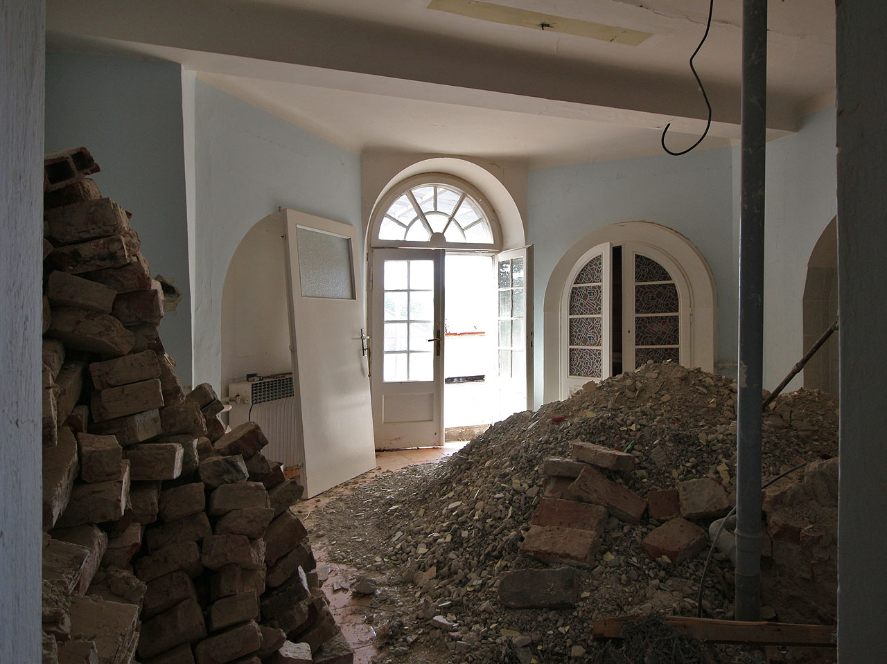 Mezi hromadami cihel lze tu a tam zahlédnout pseudorenesanční dveře vedoucí na terasy a balkóny, jichž má vila požehnaně.