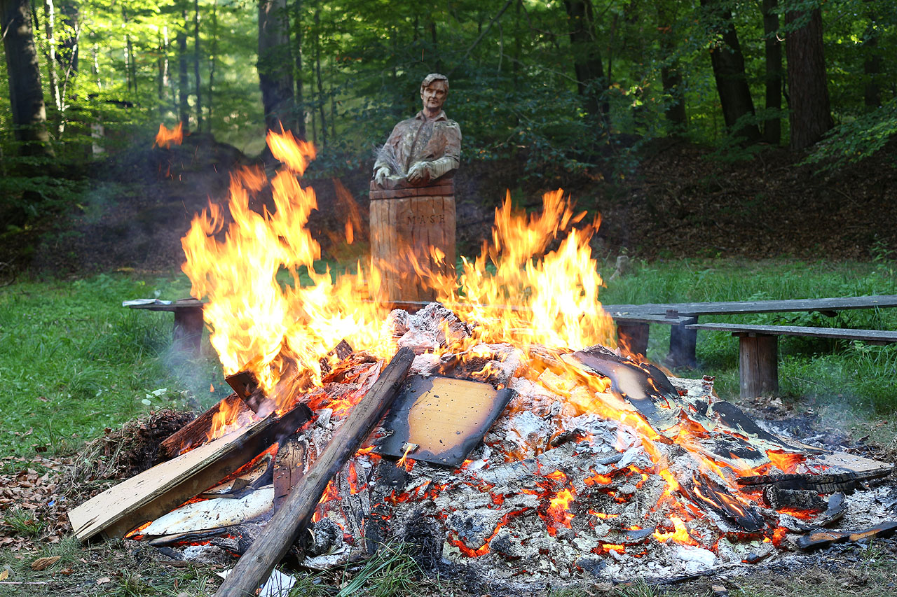 Alan Alda alias Hawkeye Pierce jen vypadá jako Jan Hus. Ve skutečnosti dohlíží na pálení dřevěného odpadu.