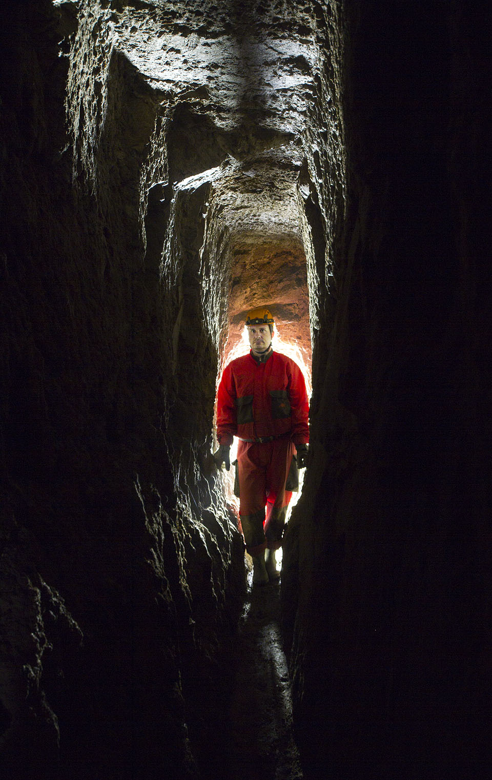 Sám Lukáš osobně se na snímků prodírá chodbou podivného tvaru, kam se člověk sotva vejde.