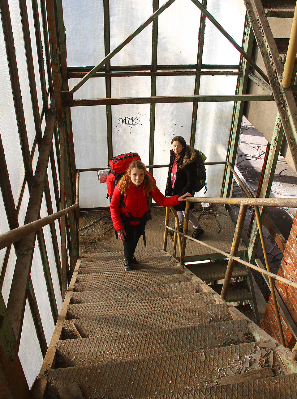 Stoupáme po proskleném únikovém schodišti s Barčou a Doubí.