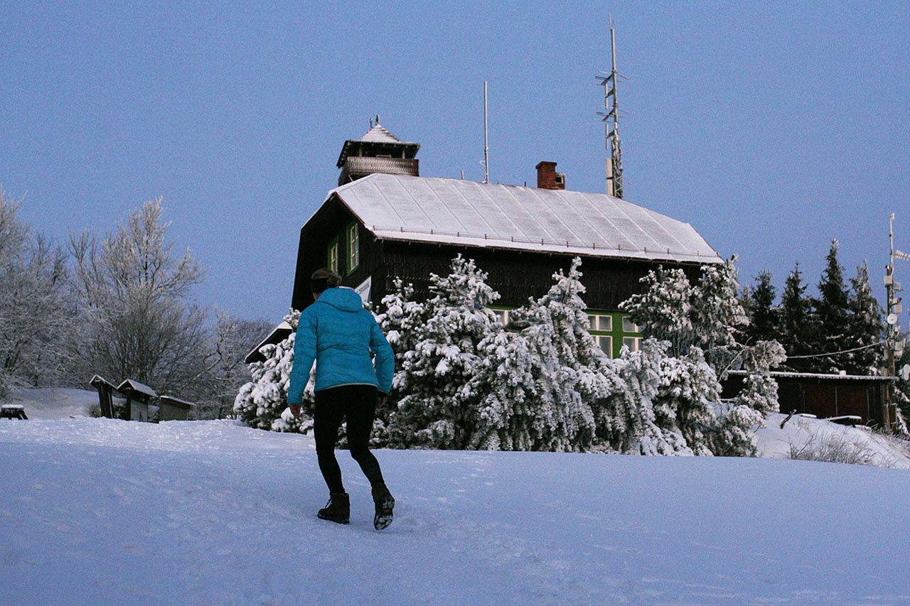 Nad turistickou chatou Pohorské jednoty vykukuje špička rozhledny z roku 2013.