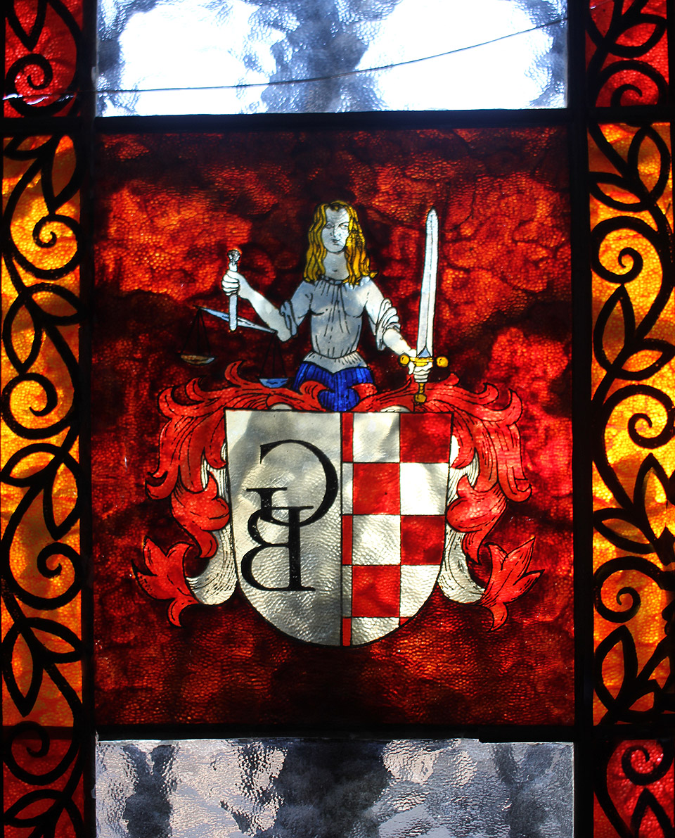 Zdánlivě luxusní vitráže s písemny G B na dveřích jsou ve skutečnosti pouze levnou plastovou nálepkou s neumělou kresbičkou. Inicály patří někdejšímu majiteli Goranu Bobanovi.