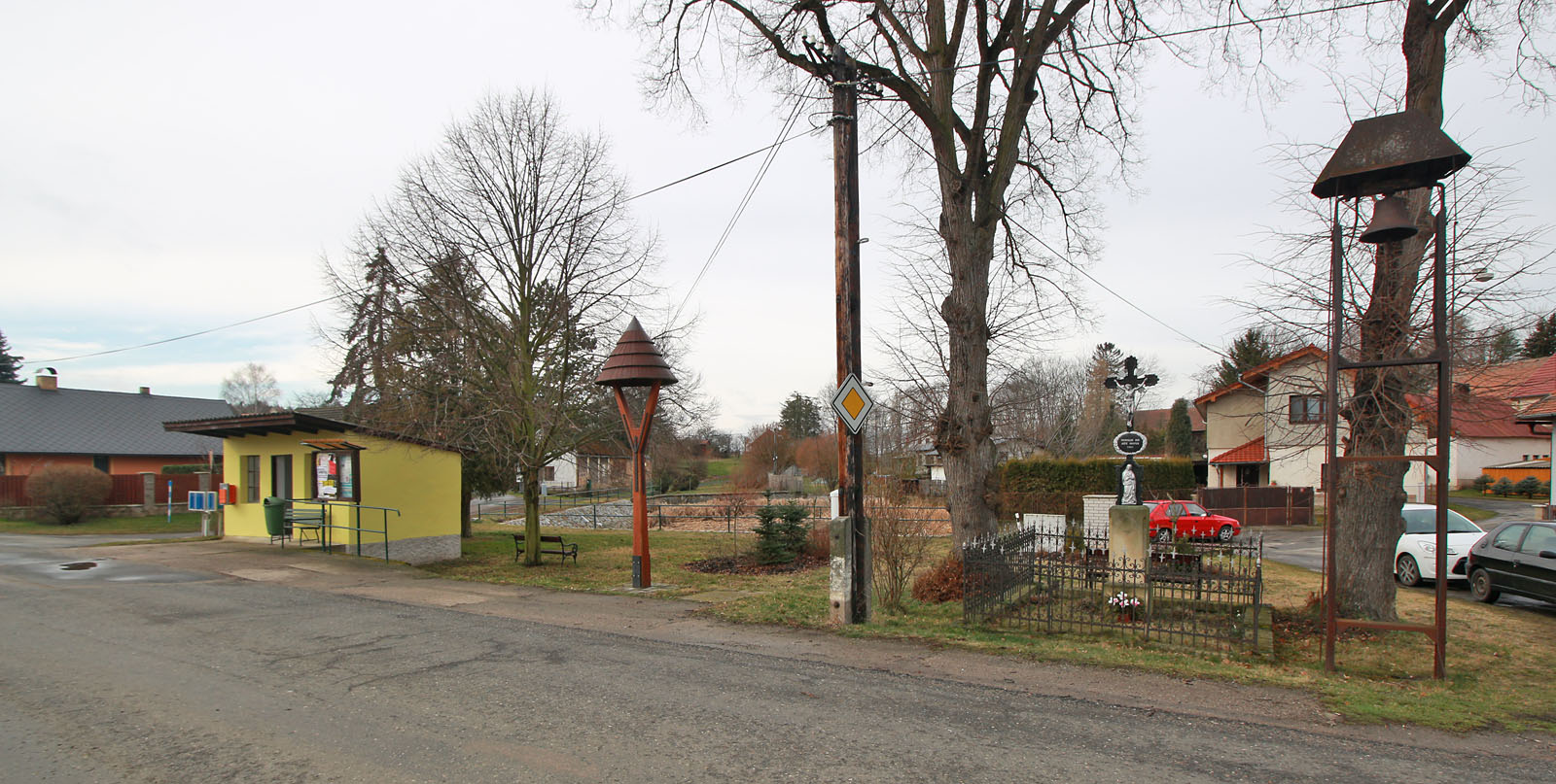 Centrum Lomce. Zastávka, zvonice, kříž a opět zvonice. Doubí je někde blízko, cítím to až v kostech a zmocňuje se mě podivný neklid.