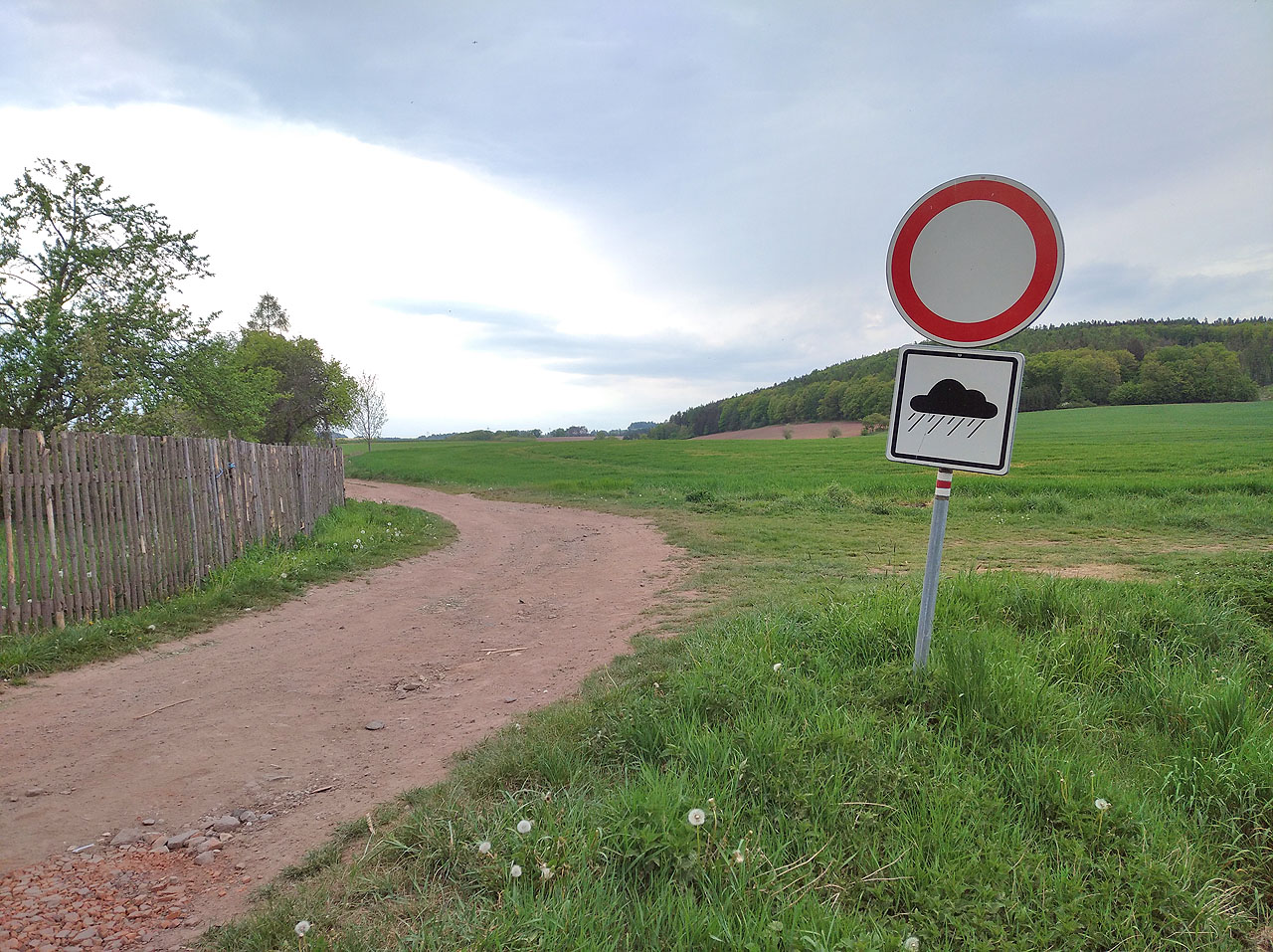 Červená značka vede po červené cestě skrze červený zákaz vjezdu platný pouze za deště, neboť tehdy se na cestě objevuje červené bahno.