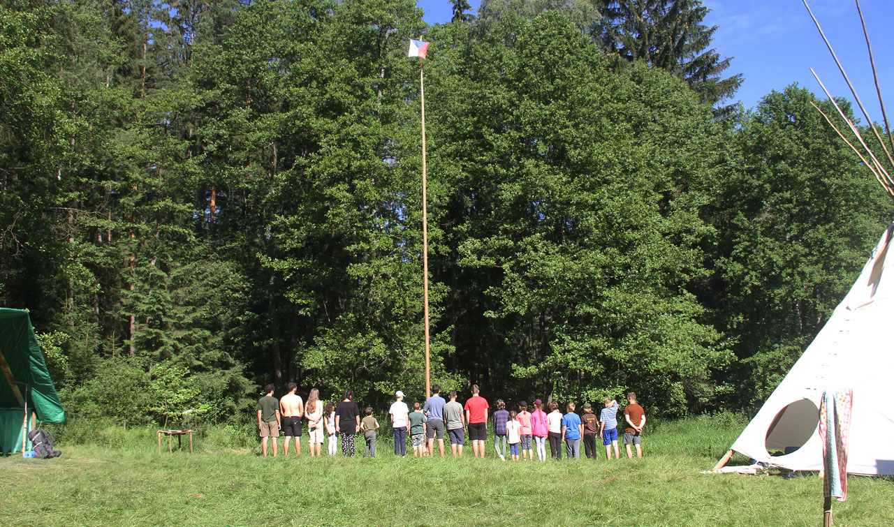 První nástup na naší loce u Brzkova, která však patří k Hrbovu. Vlajka letí vzhůru a zdola ji sleduje 21 párů očí. Kromě 4 vedoucích a zatím ještě všech 16 účastníků také Sova za stavěčku (zcela vpravo).