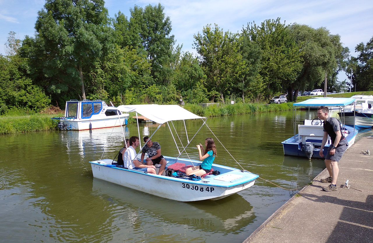 Chvíli nám trvalo, než jsme se naučili motorový člun pro šest osob nastartovat a kormidlovat. Po Baťově kanálu se smí plout rychlostí jen o málo vyšší než chůze, protože jeho břehy podléhají vodní erozi.
