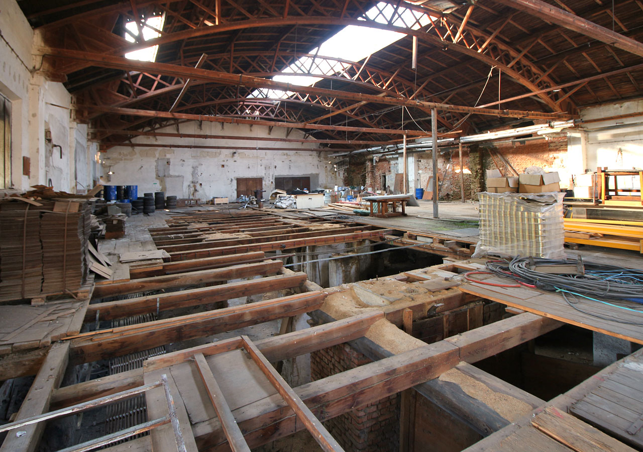 Solidní fošny z dosud stojících hal zřejmě někdo využil jinde. V podlahách zejí nebezpečné díry.